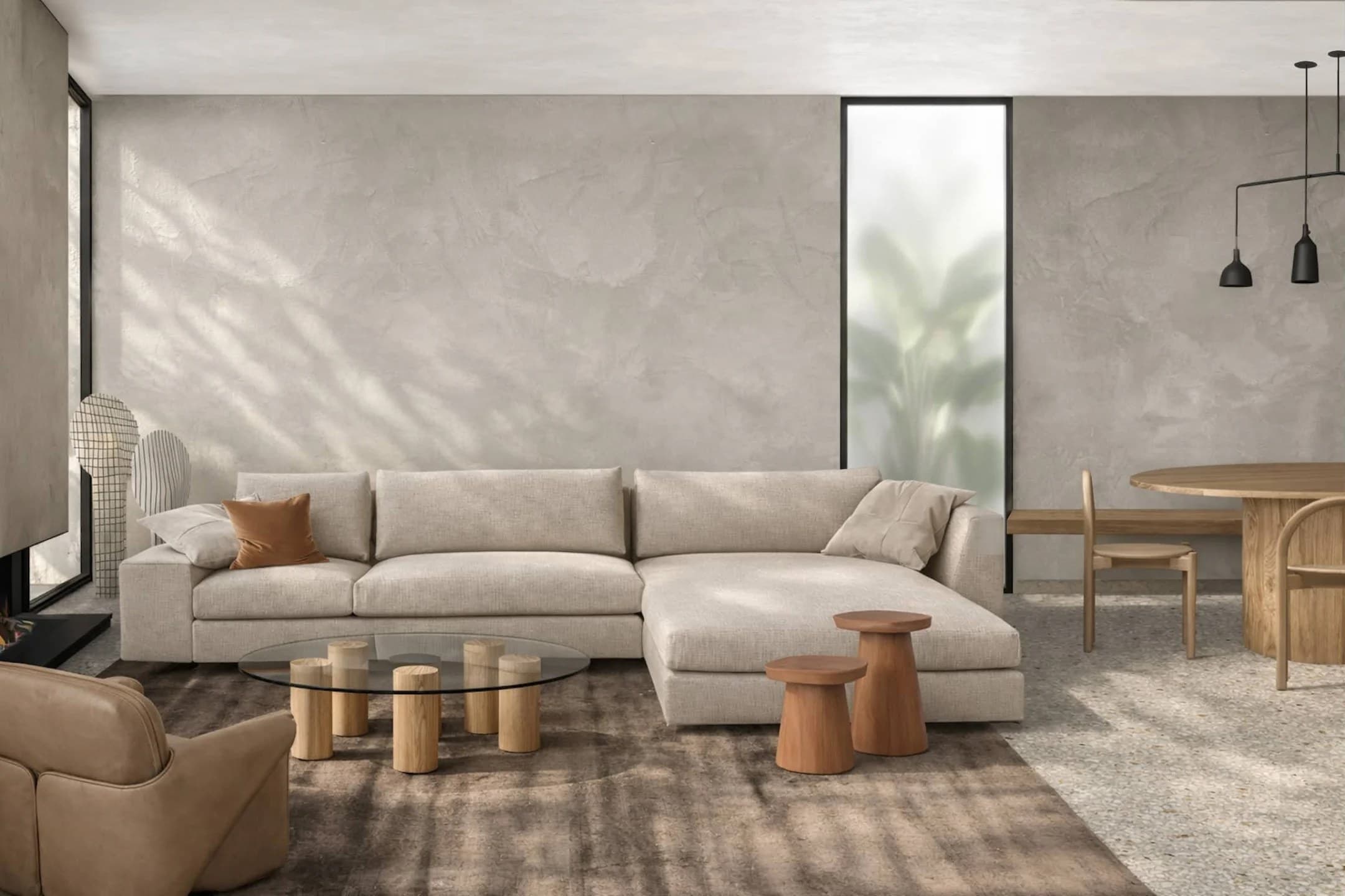 Open-plan living room with Venetian plaster walls, a cream modular sofa, a glass coffee table on oak cylinders and a timber dining table